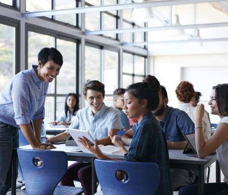 Instructor helping group of students talking in class