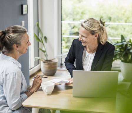 Woman smiling with a computer and helping a client
