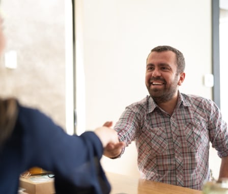 Woman and man smiling and shaking hands