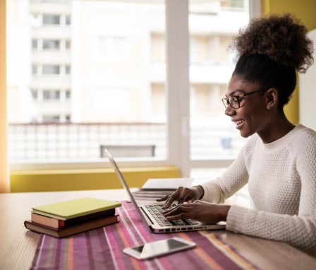 Woman smiling and typing on computer