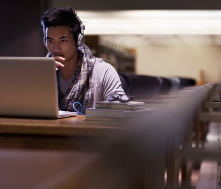 Man working on laptop in empty library