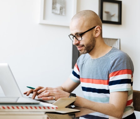 Man sitting in a comfortable office and working on a laptop