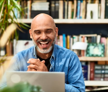 Man celebrates while looking at laptop