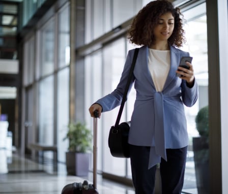 Business woman pulling suitcase through airport