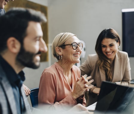 Four colleagues working together on a computer