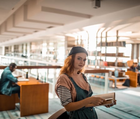 Young woman college student in library