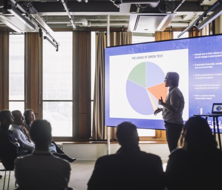 Person gives a presentation about Green Technology to a group