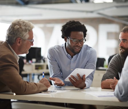 Male colleagues in a meeting, holding a tablet