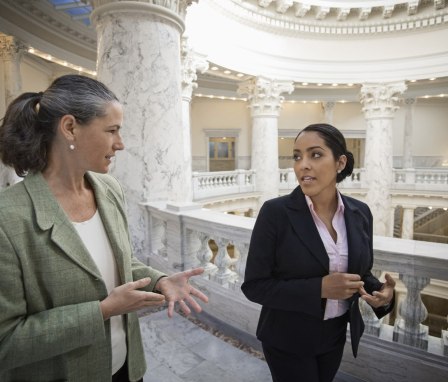 Two women politicians speaking in a government building