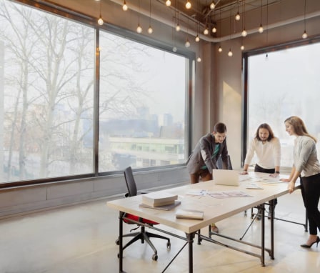 Three colleagues meeting in a big office room