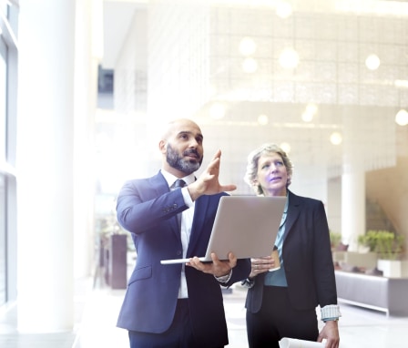 Two business people discussing plans in an office building