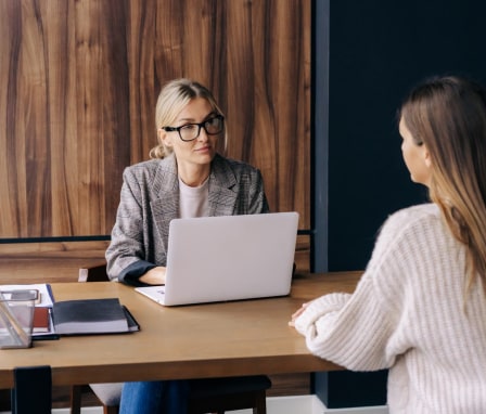 Young woman being interviewed at a desk