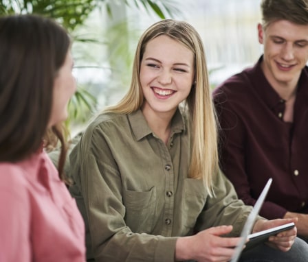 Young intern talking to and laughing with colleagues
