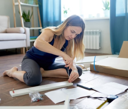 Woman assembling furniture with instructions