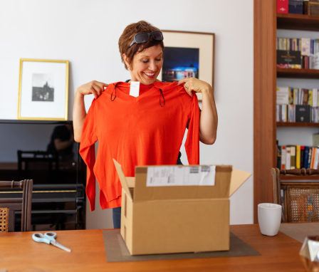 Happy woman unboxing a new sweater