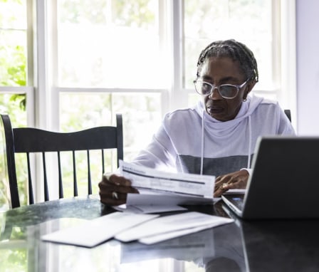 Woman paying taxes online at her kitchen table