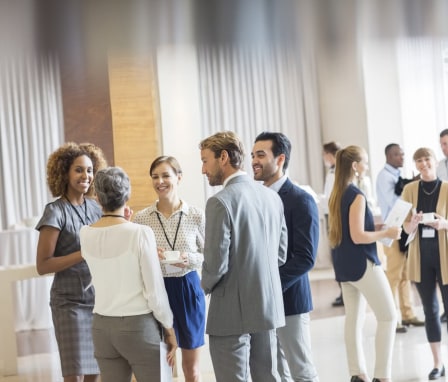 Crowd of business professionals talking and smiling