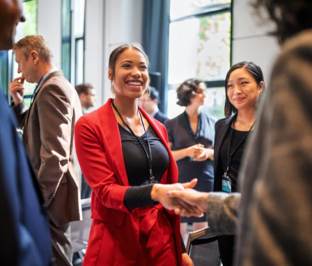 Young woman shaking hands at a networking event