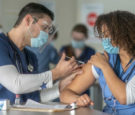African-American female nurse receiving the COVID-19 vaccine
