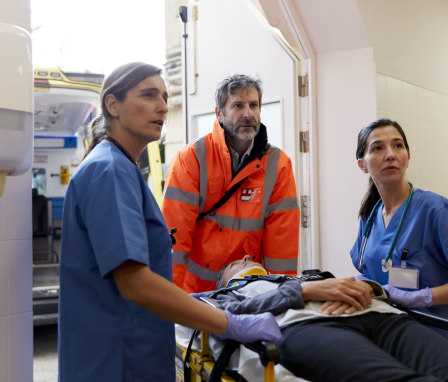 Nurses and paramedic care for patient being transported on a stretcher