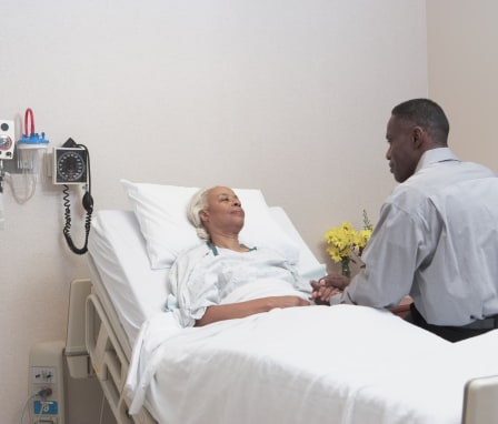 Hospital chaplain visiting patient in room