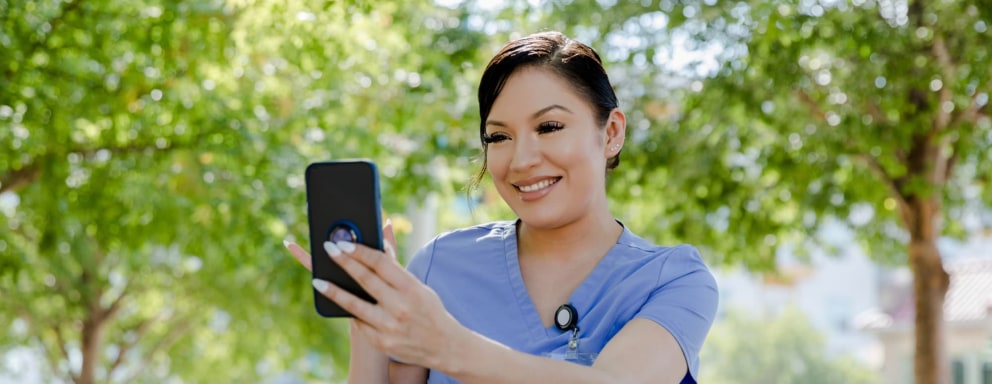 Nurse taking video with smartphone outside