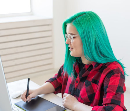 Woman drawing on a digital tablet using a desktop computer