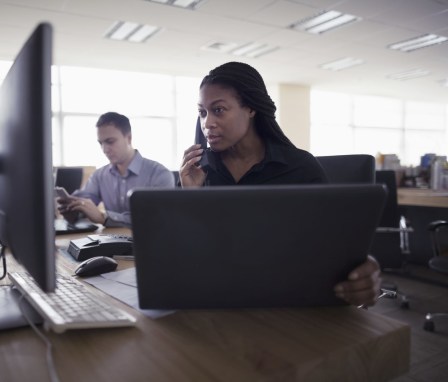 Woman on the phone in front or her work computer