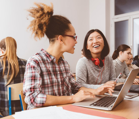 Group of women students in classroom on laptops