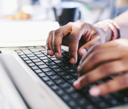 Hands typing on computer keyboard