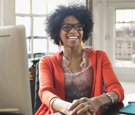 Woman smiling while sitting at computer desk