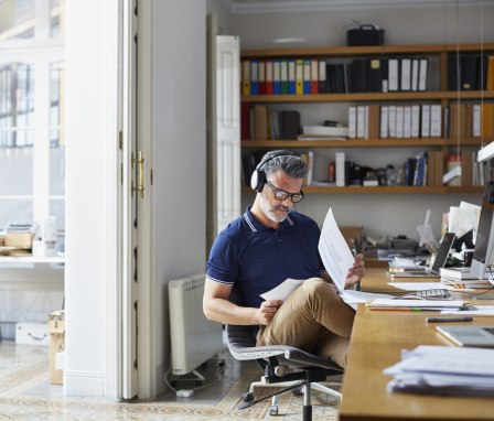 Man wearing headphones doing work at desk