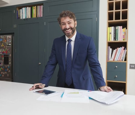 Professionally dressed man standing and smiling in office