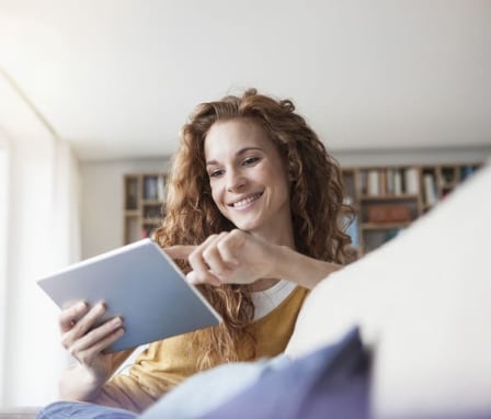 Woman smiling while using tablet