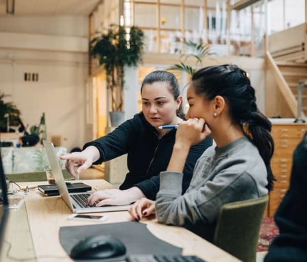 Two women working together on a laptop