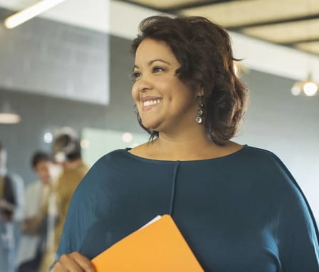 Woman smiling and holding a folder