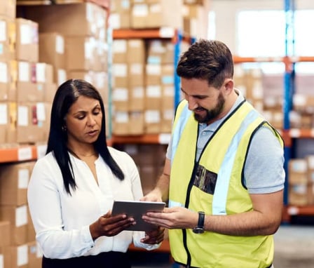 Man and woman working together on tablet in warehouse