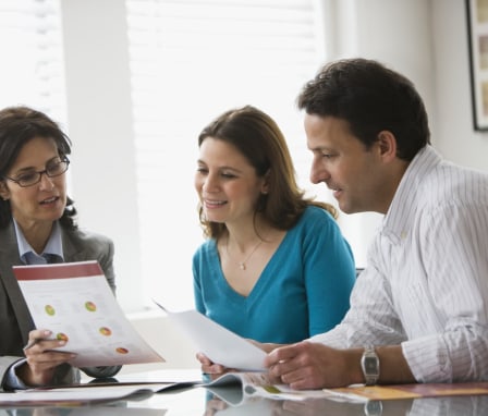 Woman with couple looking at graphs