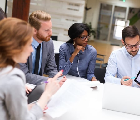 Four business colleagues looking at a graph shown on a tablet