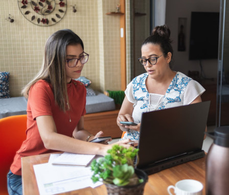 Mother and daughter doing finances together at home