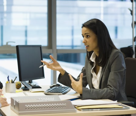 Person at computer talking to two clients