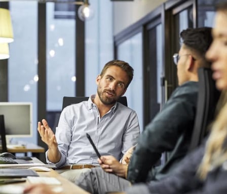 Coworkers talking at a computer desk