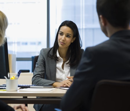 Three executives talking around a desk