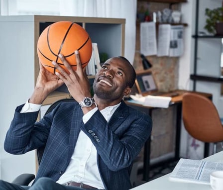 Business man in office holding basketball