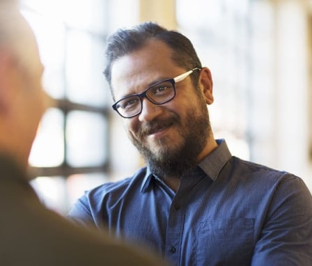 Two men smiling and talking