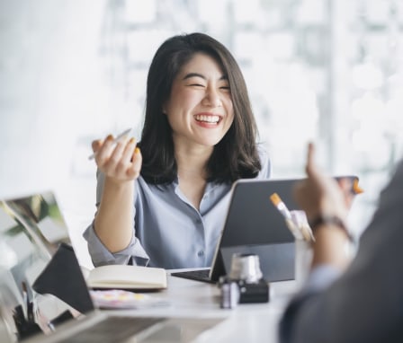 Woman in meeting smiling at desk