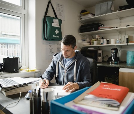 Man writing on a piece of paper in a casual office