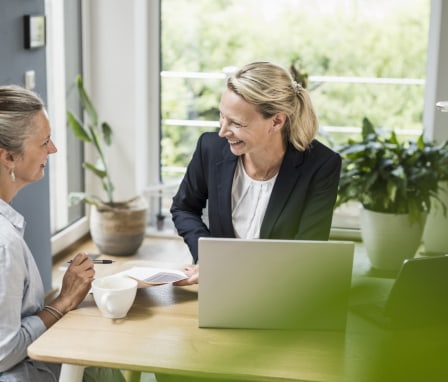 Woman smiling with a computer and helping a client