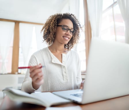 Woman studying on laptop at home