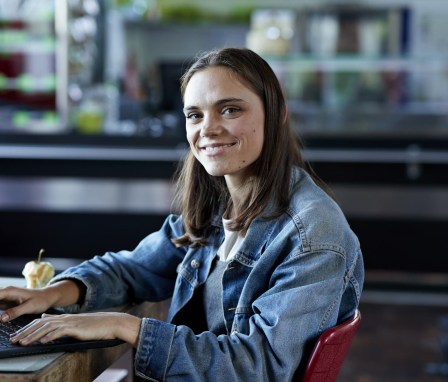 Young woman using a laptop and smiling